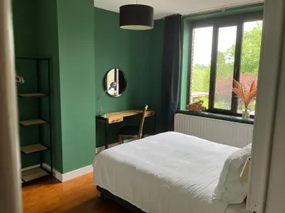 a bedroom with a bed and a desk with a mirror at Rue Haute by M&M 4 sterren bed en breakfast vlakbij Maastricht in Eben-Emael
