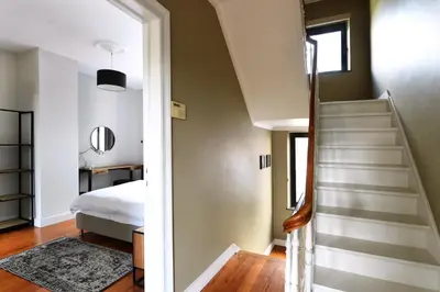 a bedroom with a stairway leading to a bed at Rue Haute by M&M 4 sterren bed en breakfast vlakbij Maastricht in Eben-Emael