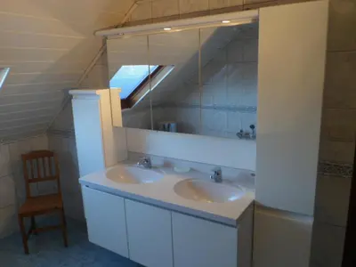 a bathroom with two sinks and a mirror and a chair at Bosrand81 in Hechtel