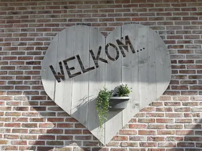 a heart shaped sign on a brick wall at B&B Cosiness in Balen