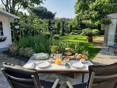 a table with food on it in a garden at B&B Cosiness in Balen