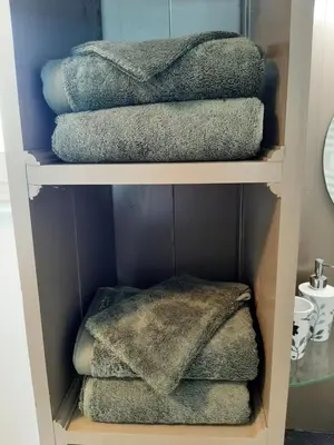 a pile of towels sitting on a shelf at B&B Cosiness in Balen
