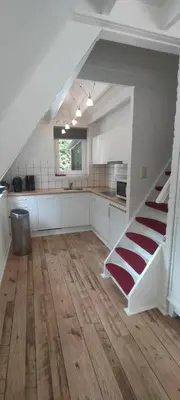 a kitchen with a staircase in the middle of a room at Lauwie 14 in Lanaken