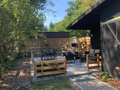 a patio with a table and chairs in a backyard at Chalet Happiness in Zutendaal