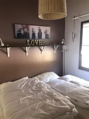 a bedroom with a bed and a sign that says love at Chalet Happiness in Zutendaal