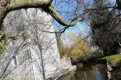 a reflection of a building and trees in the water at ländlich & gemütlich in Raeren mit 2 Schlafzimmern in Raeren