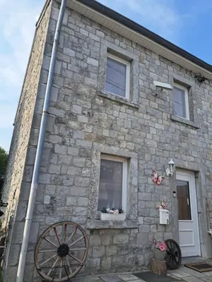 a stone building with aoked wheel outside of it at ländlich & gemütlich in Raeren mit 2 Schlafzimmern in Raeren
