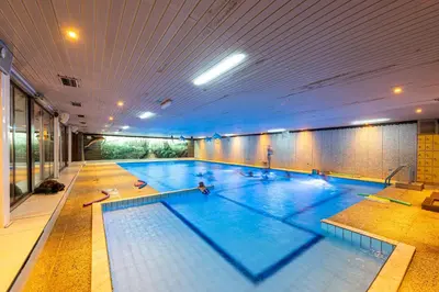 a large indoor swimming pool in a building at Glamping Belgisch Limburg in Oudsbergen