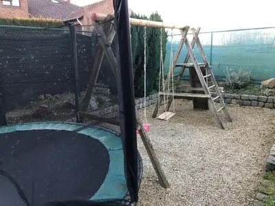 a playground with a slide and a swing set at Hoeve de Singel in Borgloon