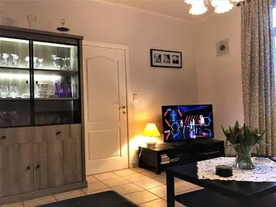 a living room with a table and a tv at Hoeve de Singel in Borgloon