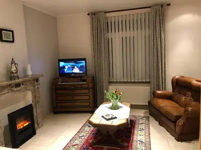 a living room with a couch and a television at Hoeve de Singel in Borgloon
