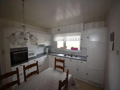 a kitchen with white cabinets and a table and chairs at Elegant & Peaceful Holiday Retreat in Peer in Peer