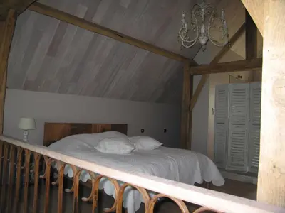 a bedroom with a bed with white sheets and a chandelier at B&B Hoeve Ransberg in Ransberg