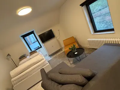 a living room with a table and a tv and a chair at Nummer 151 villastudios in Hasselt