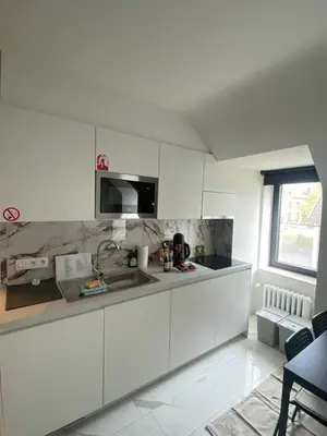 a white kitchen with a sink and a microwave at Nummer 151 villastudios in Hasselt