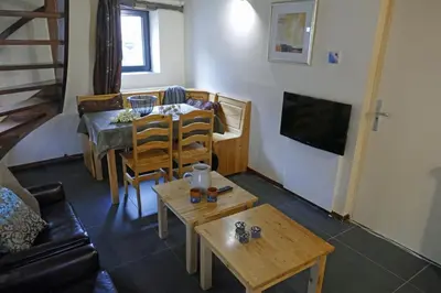 a living room with a table and a couch at Apartments Cour d'Aix in Richelle