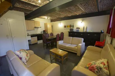 a living room with couches and chairs and a kitchen at Apartments Cour d'Aix in Richelle