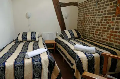 a room with two beds and a brick wall at Apartments Cour d'Aix in Richelle