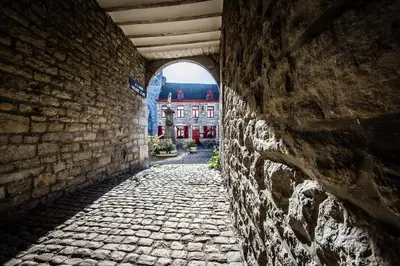 an alley with an archway in a brick wall at Une Chambre à Foyr ? in Jalhay