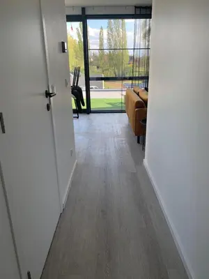 a hallway with a door leading to a living room at Gods Heide in Hasselt