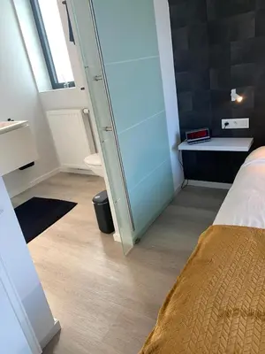 a small room with a bed and a mirror at Gods Heide in Hasselt