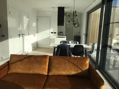 a living room with a couch and a table with chairs at Gods Heide in Hasselt