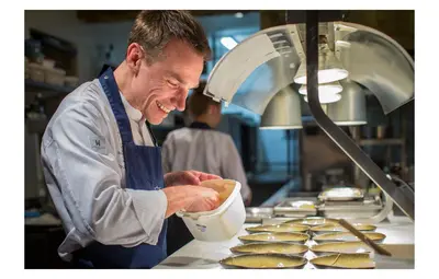 a chef is preparing food in a kitchen at Hotel Restaurant Vous lé Vous in Hasselt