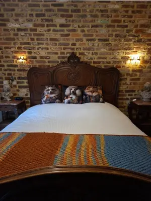 a bedroom with a bed with a brick wall at B&B Kerkevelde in Bilzen