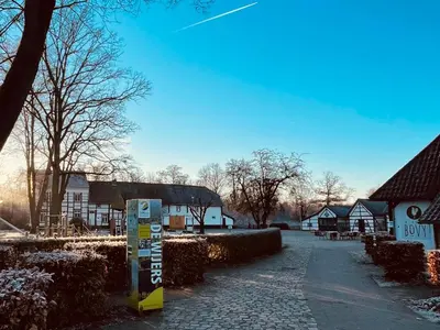 a parking meter in front of a village with houses at Sterrenheide in Heusden - Zolder