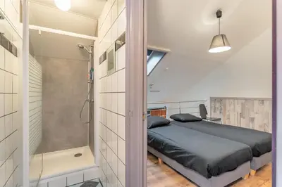 a bedroom with a shower and a bed in a room at B&B De Kroonhoeve in Beringen