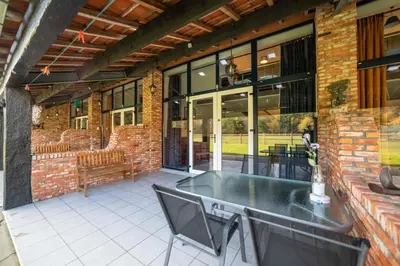 a patio with a table and chairs on a brick building at B&B De Kroonhoeve in Beringen