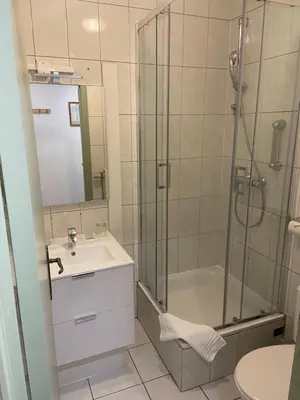a bathroom with a shower and a sink at Hotel Monika in Zutendaal