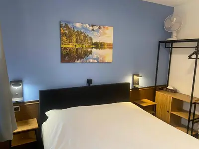 a bedroom with a bed and a painting on the wall at Hotel Monika in Zutendaal