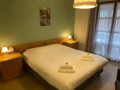 a bedroom with a bed with two towels on it at Hotel Monika in Zutendaal