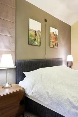 a bedroom with a bed and two pictures on the wall at Pieters Huis in Kinrooi