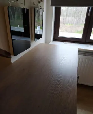 a room with a wooden table and two windows at Wonderwall in Houthalen-Helchteren