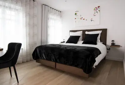 a bedroom with a large bed and a chair at 't pure genot in Dilsen-Stokkem