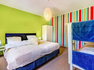 a bedroom with a large bed and a colorful wall at Alterbiezen in Hoeselt