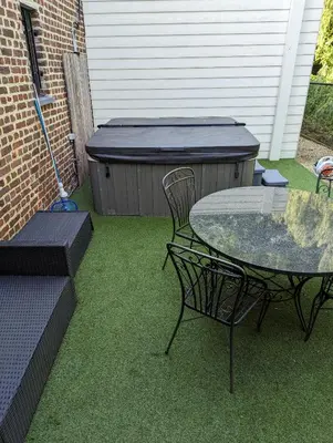 a patio with a table and a chair and a table and a grill at Alterbiezen in Hoeselt