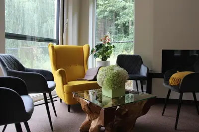 a living room with a yellow chair and a table at Alterbiezen in Hoeselt