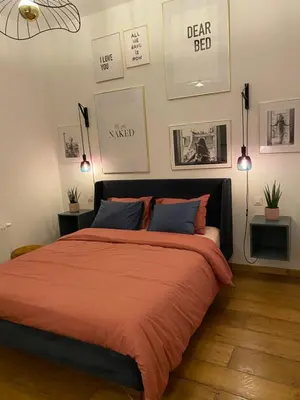 a bedroom with a bed with orange sheets and pictures on the wall at Cozy apt w/ king bed great for discovering Liege in Liège