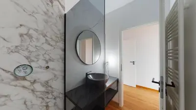 a bathroom with a sink and a mirror on a wall at Cozy apt w/ king bed great for discovering Liege in Liège
