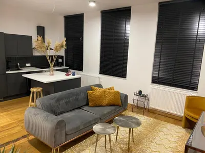 a living room with a couch and a kitchen at Cozy apt w/ king bed great for discovering Liege in Liège