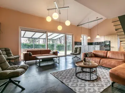 a living room with leather furniture and a table at Ons Huis in Hechtel-Eksel