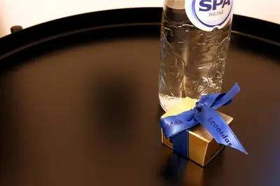 a bottle of water and a box with a blue ribbon at Marias Guest House in Eynatten