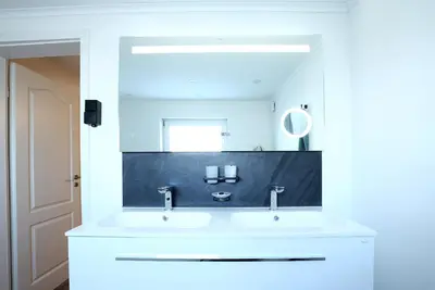 a bathroom with a white sink and a mirror at Marias Guest House in Eynatten