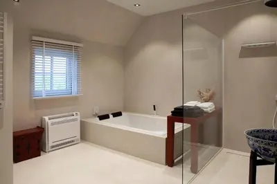 a bathroom with a bath tub and a window at 1 Bed Villa - Sleeps 2 - Garden - Parking - Wifi in Grote-Brogel