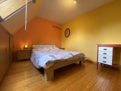 a bedroom with a bed and a clock on the wall at Drieskenshoeve in Grote-Brogel