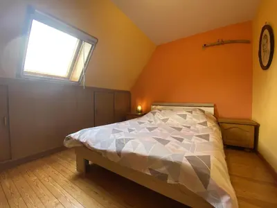 a bedroom with a large bed with a window at Drieskenshoeve in Grote-Brogel