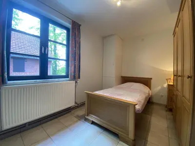 a small bedroom with a bed and a window at Drieskenshoeve in Grote-Brogel